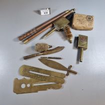 Collection of military and gun cleaning items: cleaning rods, brass trench art match cases, mops