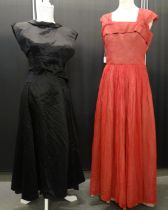 Two 1950's/60's vintage dresses to include: black satin with V neck back and red pleated sheer crepe