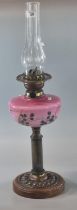 Early 20th century double oil burner lamp having pink opaline glass and floral reservoir on a copper