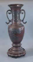 Japanese bronze Meiji period two handled baluster vase on probably associate hardwood base. The vase