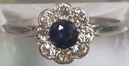 Platinum eight stone diamond daisy ring with central sapphire stone. 2.2g approx. Size K1/2. (B.P.