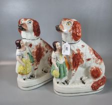 Two 19th century Staffordshire Pottery seated red and white Spaniels, each with a standing young