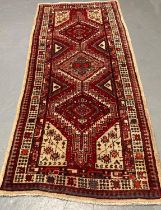 Cream and red ground Persian Mishkin runner with repeating central medallion designs and repeating