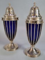 Pair of Edward VII silver sugar casters having Bristol Blue glass liners standing on circular bases,