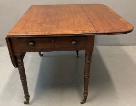 Victorian mahogany cross-banded Pembroke table on baluster ring turned legs, cups and brass casters.