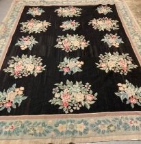 Large Aubusson style floral and foliate black ground needlepoint rug with repeating floral and