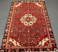 Red ground Persian Hamadan Village rug with central floral medallion. 208x127cm approx.