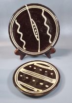 Michael Cardew, two similar pottery slipware plates in brown and cream. Impressed marks to the