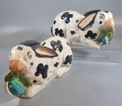 Pair of 19th century Staffordshire Pottery black and white recumbent Rabbits with leaves in their
