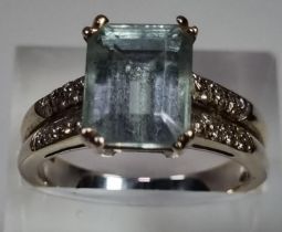 White metal aquamarine and diamond ring, the central stone flanked by an arrangement of small