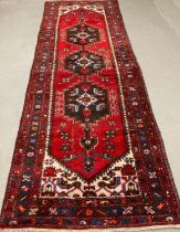 Red and blue ground Iranian runner with traditional medallion designs and repeating floral