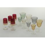 A collection of coloured footed liquor glasses