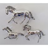 A collection of three silver models of horses