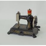 A miniature baby cast iron sewing machine