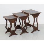 A nest of three mahogany veneered side tables