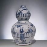 A LARGE CHINESE PORCELAIN DOUBLE GOURD VASE. PAINTED FIGURES IN A FENCED GARDEN. 33CM TALL.