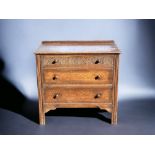 AN ENGLISH CARVED OAK SMALL CHEST OF DRAWERS.
