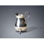 A sterling Silver tr-footed cream jug. Birmingham 1911 hallmarks. Height - 8cm