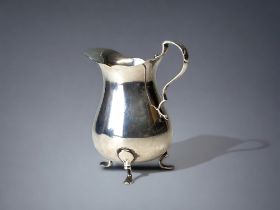 A sterling Silver tr-footed cream jug. Birmingham 1911 hallmarks. Height - 8cm
