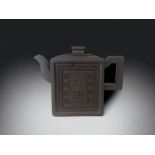 A CHINESE YIXING CLAY TEAPOT. SQUARE FORM WITH CHARACTERS INSIDE MEANDERING PATTERN BORDER. MARKED