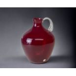 A LARGE JAMES POWELL, WHITEFRIARS GLASS JUG. 20TH CENTURY. RED GLOBULAR FORM, WITH CLEAR HANDLE.