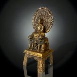 A QING DYNASTY TIBETAN GILT BRONZE SHAKYAMUNI BUDDHA FIGURE. CAST SEATED ATOP A THRONE WITH TWO LION