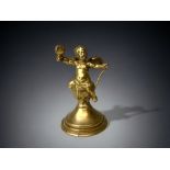 A GILT BRONZE CHERUB FIGURE. 19TH CENTURY. WINGED CHERUB SAT ON A BARREL. HEIGHT - 13CM