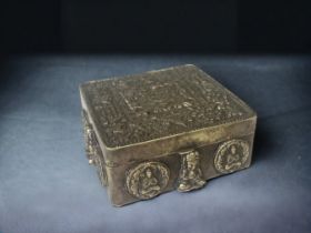 A TIBETAN EMBOSSED METAL TRINKET BOX. 9 X 8.7 X 4CM