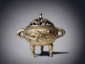 A CHINESE BRONZE TRIPOD CENSER. LATE QING DYNASTY. RELIEF DECORATED WITH PRUNUS BLOSSOM. MARKED TO