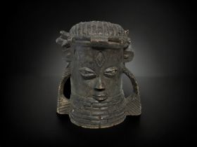 A CARVED BENIN WOODEN HEAD OF AN OBA. IN CHARACTERISTIC STYLE, WITH CORAL BEAD NECKLACE RAISING TO
