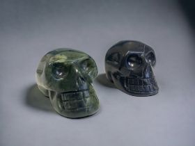 TWO CARVED STONE CRYSTAL SKULLS. 50MM LONG.