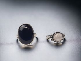 TWO STERLING SILVER LADIES RINGS. ONE SET WITH ROSE QUARTZ AND THE OTHER WITH A LARGE BLACK POLISHED