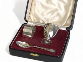 A Boxed silver christening set comprising egg cup, napkin ring and spoon. Sheffield 1939-40,