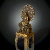 A QING DYNASTY TIBETAN GILT BRONZE SHAKYAMUNI BUDDHA FIGURE. CAST SEATED ATOP A THRONE WITH TWO