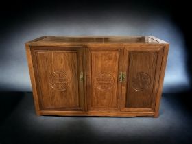 A CHINESE CARVED 'LONGEVITY' THREE-DOOR SIDEBOARD CABINET.