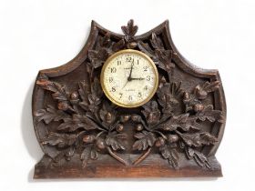 A 19TH CENTURY CARVED OAK BLACK FOREST MANTEL CLOCK. CARVED ACORNS & LEAVES. 18 X 21CM AF - WITH