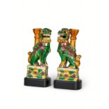 A PAIR OF CHINESE BISCUIT GLAZED FAMILLE VERTE FOO DOGS ON WOODEN STANDS, KANGXI PERIOD (1662-1722)