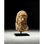 A GANDHARA STONE HEAD OF A BEARDED NOBLE MAN, CIRCA 5TH CENTURY CE OR LATER