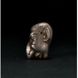 A ROMAN SOLID SILVER AMULET OF A "GROTESK" FACE, CIRCA 1ST-2ND CENTURY A.D.