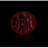 A ROMAN BLOODSTONE INTAGLIO OF THREE CONJOINED THEATRE FACES, CIRCA 1ST-2ND CENTURY A.D.