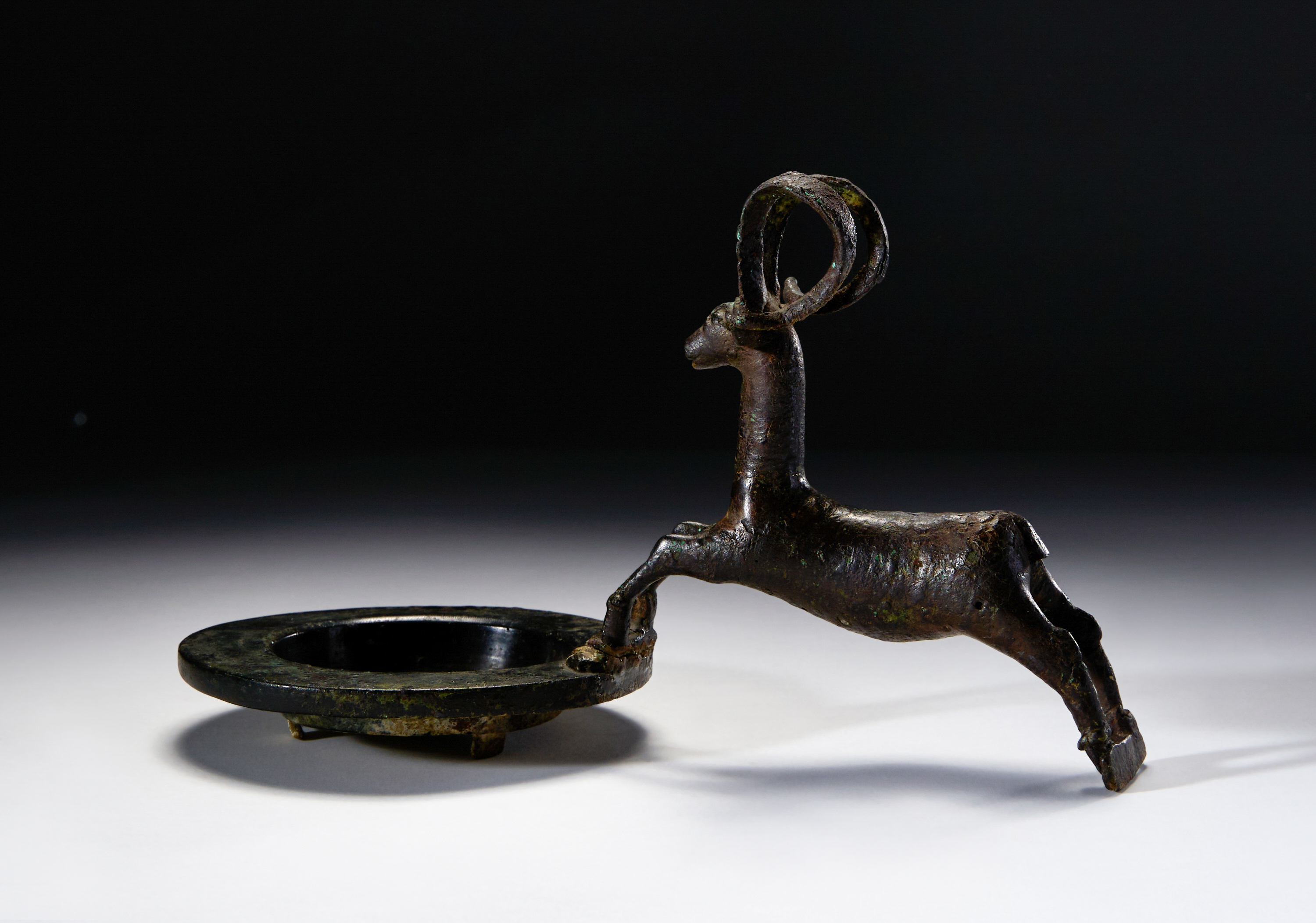 A BRONZE PLATE WITH AN IBEX