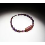 A RARE ROMAN AMETHYST NECKLACE WITH A A NEO-BABYLONIAN AMETHYST CYLINDER SEAL