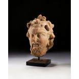 A LARGE TERRACOTTA BUST OF A SATYR'S HEAD, CIRCA 3RD CENTURY A.D. OR LATER