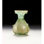A ROMAN GREEN GLASS WITH SPIKES, CIRCA 3RD-4TH CENTURY A.D.