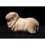 A SUMERIAN STYLE STONE FIGURE OF A RECUMBENT LAMB