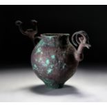 A GREEK BRONZE SPOUTED PITCHER WITH A IBEX HEAD TERMINAL