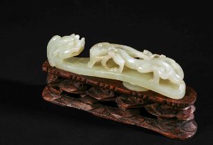 A CHINESE JADE BELT HOOK ON A WOODEN STAND, QING DYNASTY (1644-1911)