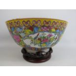 Large chinese Famille rose style bowl standing on a rosewood base. 7" Deep and 12" Diameter.