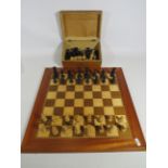 Beautifully made chess board with inlaid parquetry along with two sets of chess pieces housed in a