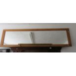 Interesting long wall mirror with long brass towel rail attached.